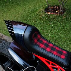 a red and black motorcycle parked in the grass