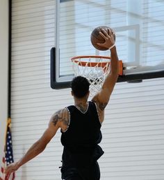 a man dunking a basketball in an indoor gym