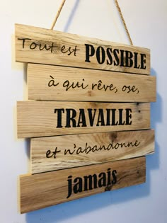 a wooden sign hanging on the wall that says tout et possle as qui rivee, one travaille et un jabanonne