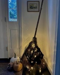 a broom is sitting on the floor in front of a door with some pumpkins