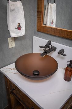 a bathroom sink sitting under a mirror next to a soap dispenser