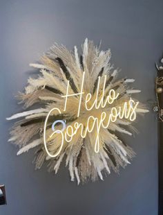 there is a neon sign that says hello gorgeous on the wall