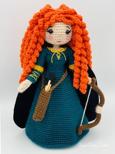 a crocheted doll with long red hair and blue dress is holding a cane