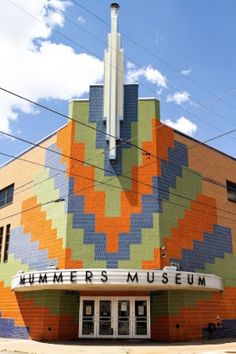 the front of a building that has a large colorful design on it's side