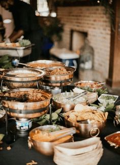 a table filled with lots of food on top of a black table covered in plates and bowls