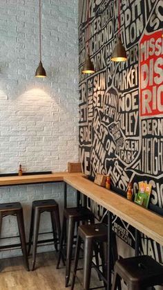 the interior of a restaurant with black and white wallpaper, wooden tables and stools