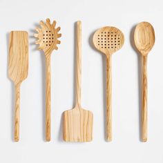 five wooden utensils lined up on a white surface