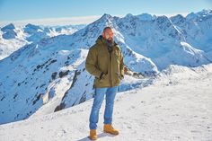 a man standing on top of a snow covered mountain