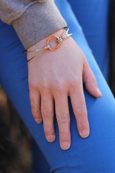 Skill Level: Beginner Time Required to Complete: 20 minutes Supplies Needed: 2 - 12 gauge 15mm ID Jump Rings 2 feet - 20 gauge Copper Wire 2 feet - 14 gauge Square Stainless Steel Wire 1 - Hook Clasp Make this stunning and distinctive piece of wearable art. Here's the tutorial for our Stainless Steel and Copper Focal Bangle. The bracelet is eye catching, comfortable to wear and offers the jewelry maker the opportunity to make something unusual. This tutorial contains clear color photos and easy Modern Adjustable Jewelry With Soldered Detail, Adjustable Copper Jewelry In Wearable Art Style, Handmade Modern Copper Jewelry, Modern Handmade Copper Jewelry, Adjustable Nickel-free Jewelry In Wearable Art Style, Silver Circle Earrings, Oxidized Silver Earrings, 12 Gauge, Pretty Bracelets