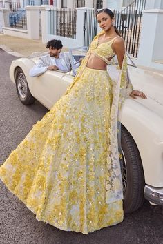 Ivory based lehenga with an attached cancan featuring yellow three-dimensional floral highlighted with crystal, pearl and sequins. Comes with coordinating padded blouse and a four sided embroidered dupatta. - Aza Fashions Yellow Indian Lehenga, Minimalist Mendhi, Bridal Garba Outfit, Mendhi Night Outfits, Modern Indian Clothes, Pastel Yellow Lehenga, Seema Gujral Lehenga, Strapless Lehenga, Yellow Indian Wear