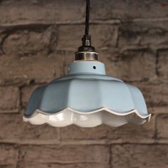 a blue light hanging from a brick wall with the words murano sky ceramic pendant light by linggad ceramics