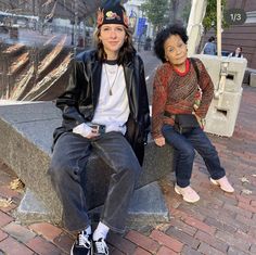 two people sitting on a bench in the city