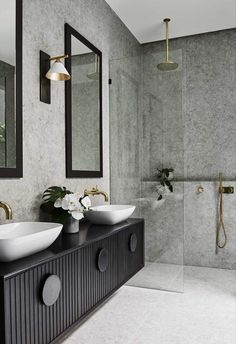 a bathroom with two sinks and mirrors on the wall