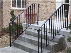 a set of stairs leading up to a brick building with a potted plant on the side