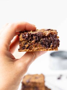 a hand holding a chocolate chip cookie bar