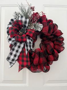 a red and black wreath hanging on the front door