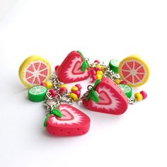 a bunch of fruit key chains on a white surface with one piece cut in half