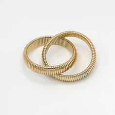 Boost your style with the Porter Bangle Stack, a stunning 18K gold and rhodium filled bracelet featuring an intertwined 14mm wide coil design. This sophisticated piece is both unique and versatile, perfect for the confident, fashion-forward woman. Meticulously crafted for comfort and durability, it's the perfect accessory you'll reach for every day. Bracelets come together 70mm in diameter stretch bangle design 18k gold filled demi-fine Gold Jubilee Stretch Bracelet For Formal Occasions, Slinky Flexible Bangle Bracelet, Gold Bracelets With Polished Finish And Modern Twist, Modern Twist Gold Bracelets With Polished Finish, Elegant Gold Spiral Bangle, Elegant Yellow Gold Flexible Stretch Bracelet, Gold Flexible Slinky Bracelet, Elegant Gold Stretch Bracelet With Jubilee Style, Elegant Gold Stretch Bracelet For Formal Occasions