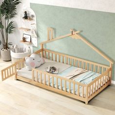 a baby's bed with a wooden frame and mattress on the floor in front of a green wall