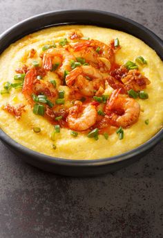 a bowl filled with shrimp and grits on top of a table