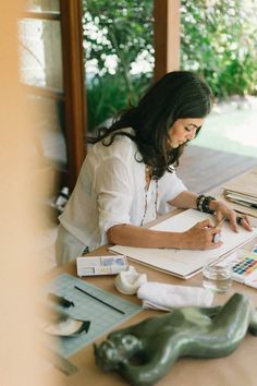 a woman sitting at a table working on something