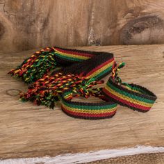 multicolored bracelets with tassels on wooden surface next to wood plank