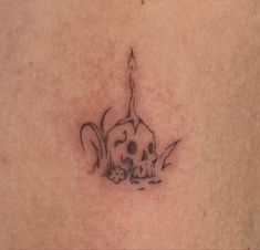 a skull and candle tattoo on the stomach