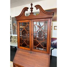 an old wooden china cabinet with glass doors