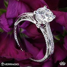 a close up view of a diamond ring on purple flowers with the words verragio written below it