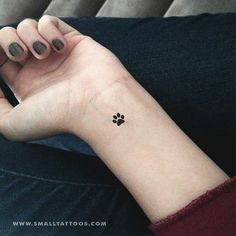 a woman's arm with a small paw tattoo on the left side of her wrist