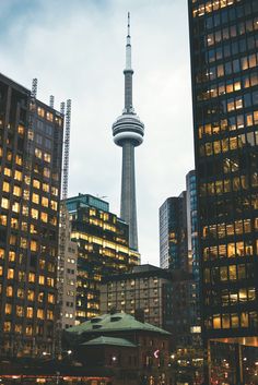 the city skyline is lit up at night, with skyscrapers in the foreground