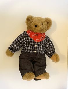 a brown teddy bear with a red bandanna around its neck and jeans on it's legs