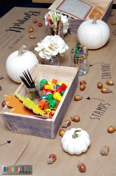 there is a wooden box filled with crafting supplies on the table next to pumpkins