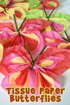 tissue paper butterflies on a table with the words tissue paper butterflies written in red and green