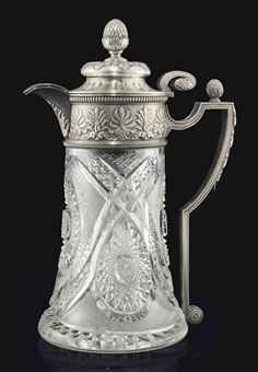 an ornate silver coffee pot on a black background