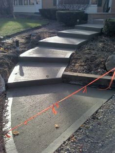 concrete steps leading up to a house in the fall with orange tape on each step