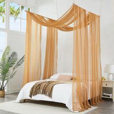 a bed with sheer curtains hanging over it