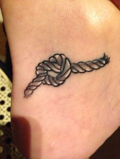 a woman's foot with a tattoo on it that has an arrow in the middle