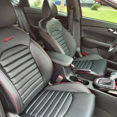 the interior of a car with black leather and red stitching