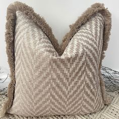 a brown and white pillow sitting on top of a rug