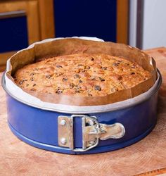 a cake in a blue pan sitting on top of a wooden table