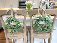 two chairs with wreaths on them in a kitchen