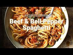 a bowl filled with pasta and meat on top of a wooden table