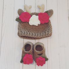 a crocheted deer hat and booties are laying on the white wood floor