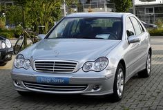 a silver mercedes benz parked in front of a building