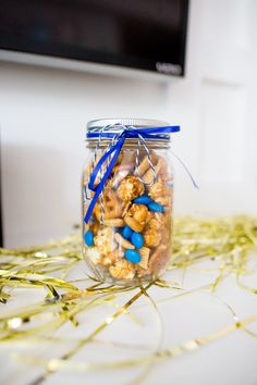 a glass jar filled with blue and white sprinkles on top of a table