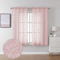 a pink curtain hanging in front of a window next to a white dresser and lamp