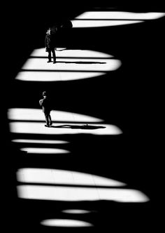 two people are standing in the shadows of light