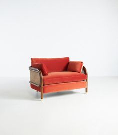 an orange couch sitting on top of a white floor