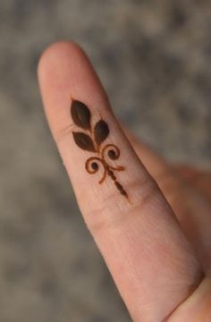 a person's hand with a small tattoo on it that looks like a flower